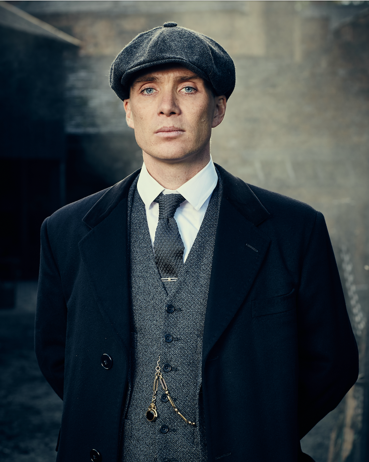 Tommy Shelby en costume trois-pièces, casquette et montre à gousset